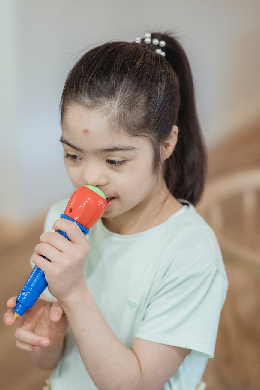 a young girl holding a toy microphone