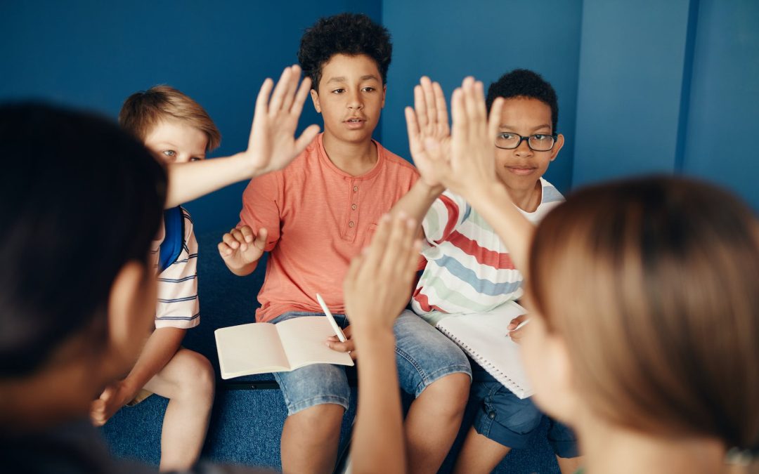 a group of kids sitting on blue couch raising their hands