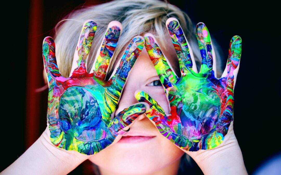 a kid with multicolored hand paint