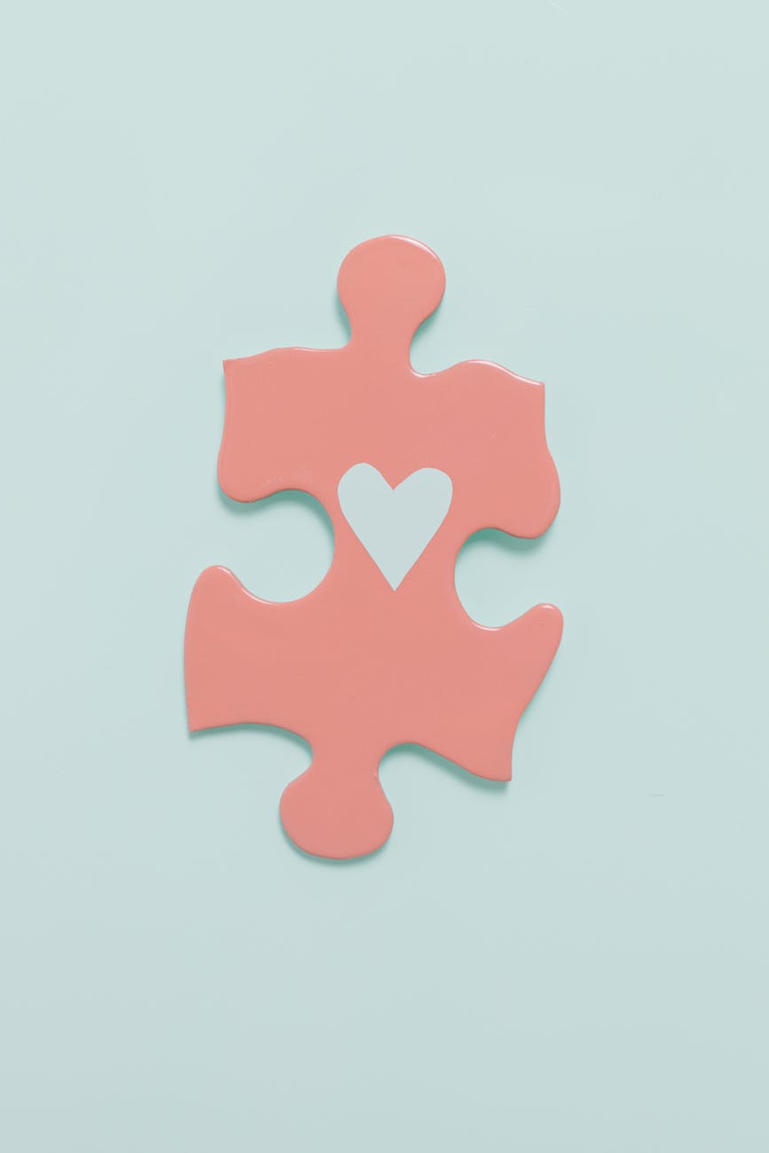a pink jigsaw puzzle piece with drawing of a heart